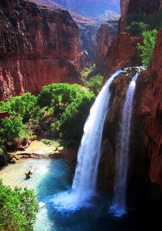 a large waterfall is in the middle of a canyon