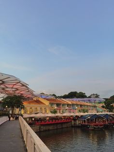 several boats are docked in the water next to some buildings and umbrellas over them