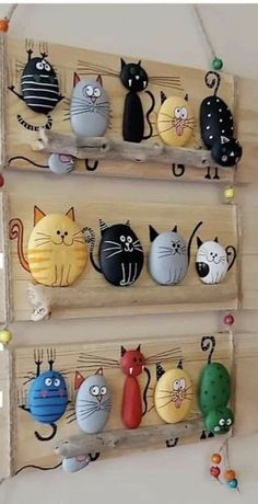 three wooden shelves with cats painted on them and hanging from the wall, each holding several different types of magnets