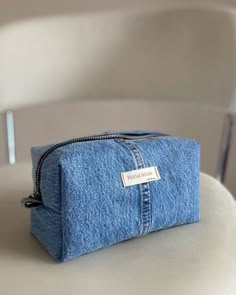 a denim pouch sitting on top of a white chair