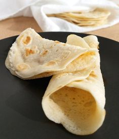 two pieces of pita bread on a black plate