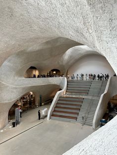 people are standing in the middle of a building with stairs and steps leading up to it