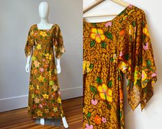 This authentic 1960s Tahitian made dress will bring the tropics to wherever you wear it!  This vintage 60s maxi dress features beautiful flutter sleeves and a fun retro tropical hibiscus print made of mocha and caramel browns, orange, yellow, pink, lime green, and grass green.  The bust and body of the dress are lined with a second layer of the printed fabric while the sleeves flow freely unlined a touch more sheer.  A white zipper in the back of the dress makes this a fitted empire waist column style dress with an illusion of being a slim caftan. It was made in Papeete, the capital of the island of Tahiti in French Polynesia, by Designer "Marie Ah You Couture" and is made of a lightweight cotton gauze.  Tag: Marie Ah You Couture Papeete_Tahiti Material: Thin Woven Cotton  Size: US size S/ Retro Tropical Print Dress For Vacation, Retro Tropical Print Vacation Dress, 1970s Floral Beach Dresses, Vintage Tropical Print Dresses For Spring, Vintage Dresses With Tropical Print For Spring, Vintage Tropical Print Beach Dress, Vintage Beach Dress With Tropical Print, Vintage Dress With Tropical Print For The Beach, Vintage Tropical Print Dresses For Vacation