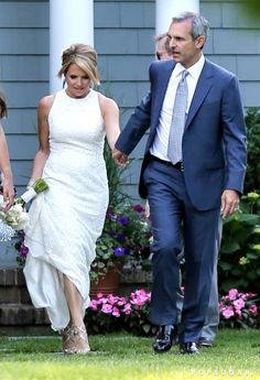 the bride and groom are walking together outside