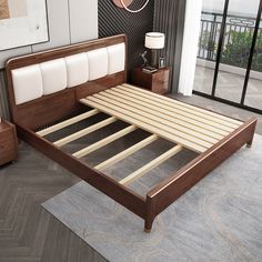 a bed with wooden headboard and foot board in a room next to a window