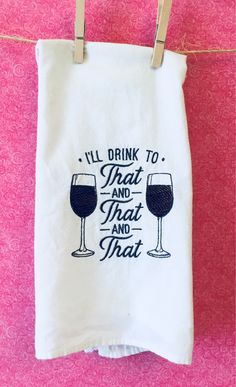 a tea towel hanging on a clothes line with two glasses of wine in front of it