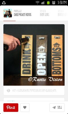 two wooden signs with the words drink up and down on them are being held by a person's hand