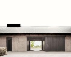 the entrance to an empty building with metal roofing and doors on both sides, surrounded by hay bales