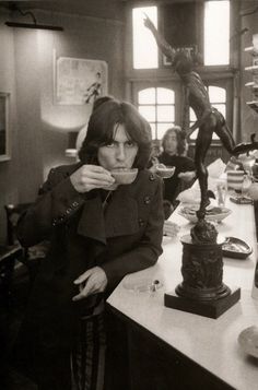 black and white photograph of woman sitting at desk with statue in background