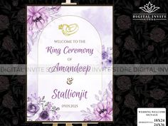 wedding welcome sign with purple flowers and gold rings on it's back, in front of black floral background