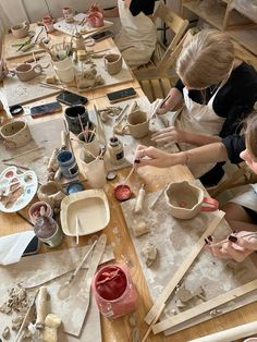 two women working on pottery at a table