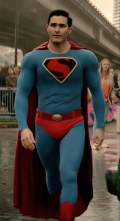 a man dressed as superman walking down the street