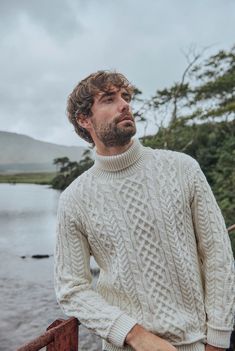 On-trend, traditional, contemporary, time-honoured. The Kylemore Aran Polo Neck Sweater truly encapsulates the blend of old and new. The tradition of Aran stitching is celebrated here with a carefully selected blend of cable, honeycomb, moss and diamond stitches displayed across the knit. The effortlessly modern and on-trend turned down polo neck gives this knit a new feel, while still honouring the history of Aran. Moving forward and rooted in heritage. Mens Knitted Sweater, Mens Cable Knit Sweaters, Cable Knit Sweater Men, Men’s Knit Sweater, Winter Cable Knit Polo Sweater, Cozy Cable Knit Wool Polo Sweater, Cable Knit Sweater, Men Cable Knit Sweater, Cable Knit Sweater For Guys