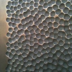 a metal surface with circles and holes on it