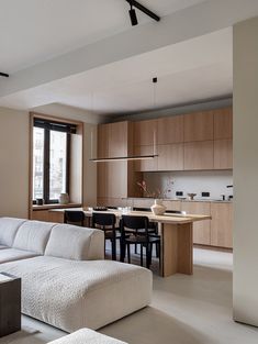 a living room filled with furniture next to a kitchen