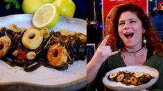 a woman holding a plate of food next to a pile of fried shrimp and lemons