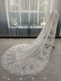 a wedding veil on the ground in front of a window