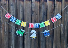 a banner that says school is in front of a wooden fence with cars on it