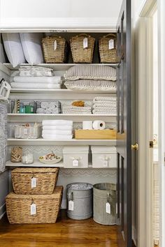 an organized closet with baskets, towels and other items in it's shelving