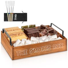 a wooden box filled with marshmallows, chocolate and other sweets next to an arrow