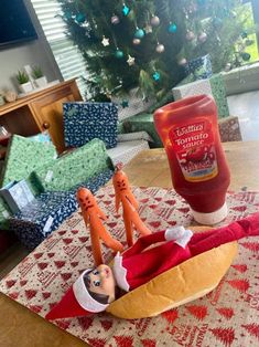 a hot dog sitting on top of a table next to a bottle of ketchup