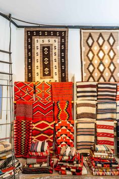 many colorful rugs and pillows on display in a room