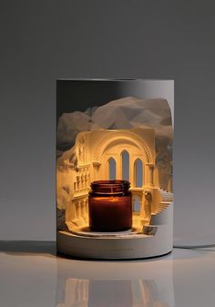 a candle that is sitting on top of a table in front of a building with stairs