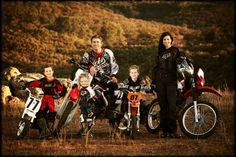 a group of people standing next to each other on dirt bikes