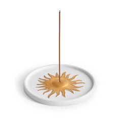 a white plate with a wooden stick sticking out of it's center and sun design on the side