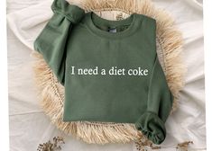 "I Need A Diet Coke Sweatshirt, Diet Coke Bottles, Gift for Diet Coke Lover, Soda Gift Crewneck, Funny Gift Sweatshirt Soda Lover, Funny Coke Size and Colors : - Check images for sizing details and color options. Measurement Notes: - Lay the garment flat. Width is measured 1\" below armhole at bust level. - Body length is measured from the back centerline seam to the underside of the front hem. Care Instructions: - Turn the garment inside out and wash cold on a delicate program. Lay flat to dry. - Do not bleach, dry clean or iron directly on the design. Processing time : - Standard processing is 1-3 business days before shipping your orders. For rush transaction, please visit the \"upgrade\" list and contact us before purchasing. Distribution time: - Standard shipping takes 3-6 days to del Diet Coke, Dec 1, Cuff Sleeves, Color Chart, Shirt Ideas, Types Of Shirts, Jersey Shorts, Comfort Colors, Lay Flat