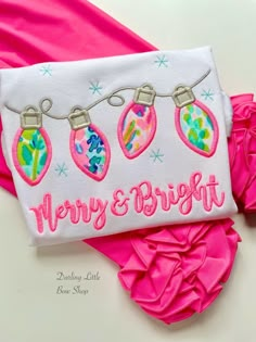 a pair of pink shorts with christmas ornaments on them and the words merry and bright