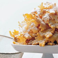 a white plate topped with macaroni and cheese covered in powdered sugar on top of a table