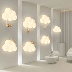 a room with white walls and clouds on the wall, suspended lights in the ceiling