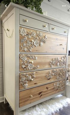 an old dresser has been painted with flowers and leaves on the top, along with white furnishing