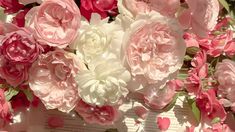 pink and white flowers are arranged on top of an open book with pages in the background