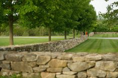 a stone wall with trees in the background