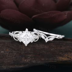 a diamond engagement ring sitting on top of a piece of wood