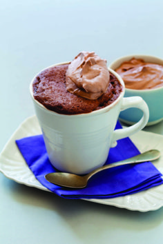 two mugs filled with chocolate pudding on top of a blue and white place mat