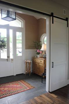 an open door leading to a bedroom with a rug on the floor next to it