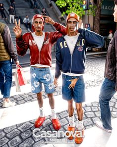 three men standing next to each other in front of some stairs with their hands up