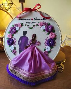 a purple dress with flowers on it sitting on top of a table