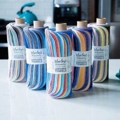 four spools of multicolored yarn sitting on a counter top next to each other