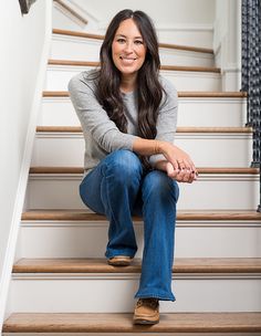 a woman is sitting on the stairs smiling