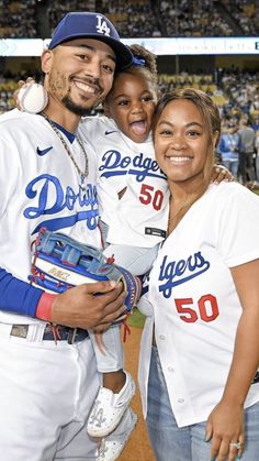 a man and woman posing for a photo at a baseball game with the dodgers on their shirts