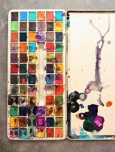 an artist's palette and watercolors in a box on a table top