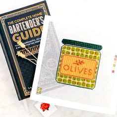 the complete home bartender's guide is next to a cross - stitch book cover