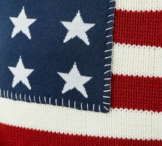 an american flag knitted sweater with white stars on the chest and red, white, and blue stripes