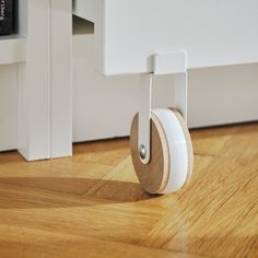 a small wooden wheel on the floor next to a wall