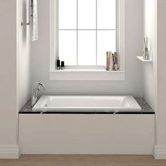 a white bath tub sitting under a window