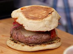 a hamburger with meat and cheese on a wooden cutting board